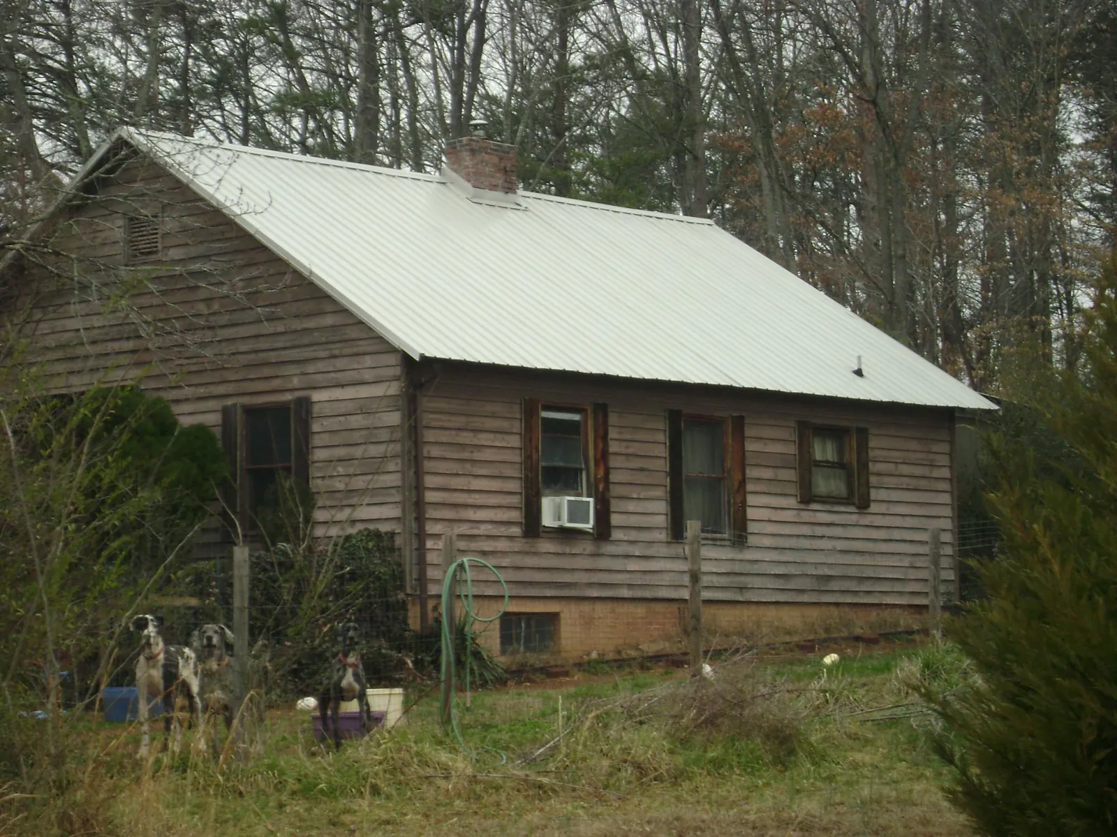 White metal roof on an old wood sided farmhouse, from a Metal Roof Installation job in Howells